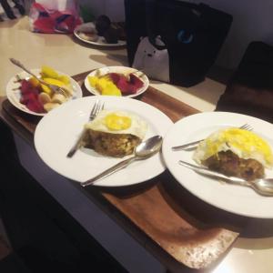 a table with two plates of food with eggs on them at Melaya Beach Resort Queen Bed in Penginuman