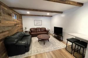 a living room with a leather couch and a television at The GingerBreck House in Breckenridge