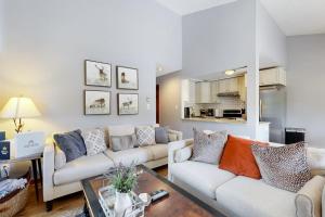 a living room with two couches and a table at Lakeview Townhome Unit A5 in Avon