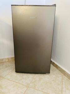 a metal refrigerator sitting on the floor in a room at Peaceful Seaside Apartments in Vaia