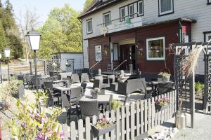 a restaurant with tables and chairs in front of a building at hotel spiegeltaler eck in Wildemann
