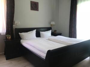 a bed with white sheets and pillows in a bedroom at hotel spiegeltaler eck in Wildemann