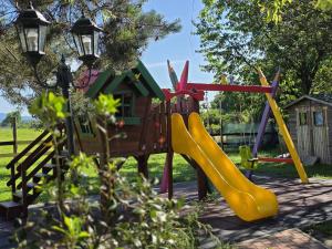 a playground with a slide and a house at Sobe - Klet Cinkuš in Hrvatski Leskovac