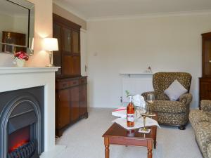 a living room with a fireplace and a chair at The Warren in Seasalter