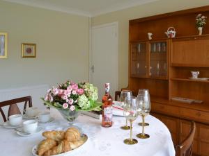 a table with a vase of flowers and wine glasses at The Warren in Seasalter
