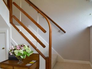 a staircase with a vase of flowers on a table at The Warren in Seasalter