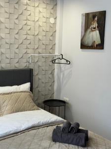 ein Schlafzimmer mit einem Bett und einem Gemälde an der Wand in der Unterkunft Studio Lite Ermou#17 in Kateríni