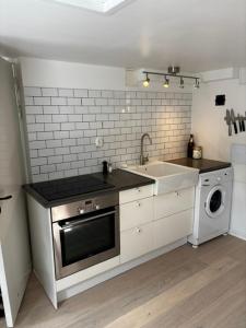 a kitchen with a sink and a washing machine at Roslags Näsby Täby in Täby