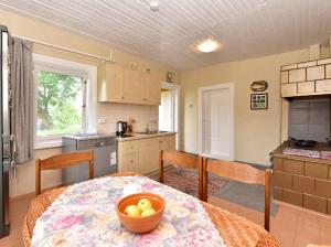 a kitchen with a table with a bowl of fruit on it at Sodyba Po liepom in Krikštonys +20 photos