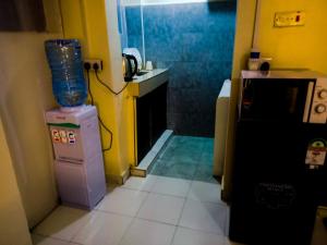 a small room with a small bathroom with a kitchen at SHAHMERALD Stays Studio in Kakamega