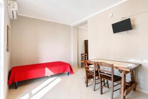 a room with a table and chairs and a red blanket at Villa Mapa - Appartamenti Lorusso in Vieste