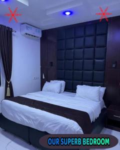 a bedroom with a large bed with a black headboard at Britney Luxury Apartment in Owerri