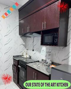 a kitchen with a stove and a microwave at Britney Luxury Apartment in Owerri