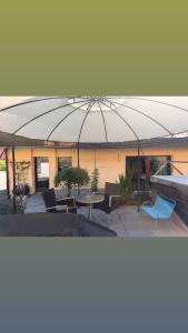 a large umbrella over a patio with chairs and a table at Ferienwohnung an der Seez in Mels
