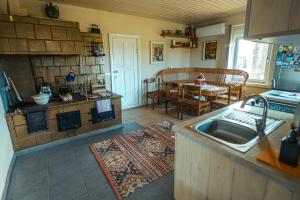 a kitchen and living room with a sink and a table at Sodyba Po liepom in Krikštonys