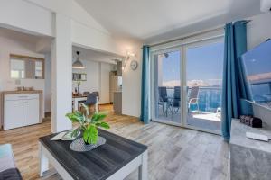 a living room with a table and a large window at 2Bfree Apartments in Stinica