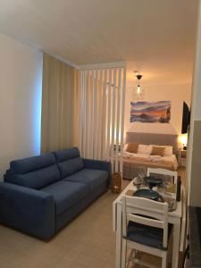 a living room with a blue couch and a bed at Monolocale 100metri dal mare in Fano