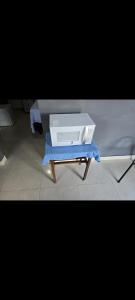 a white appliance sitting on a stand on a table at Microcasa 6 in Lajeado