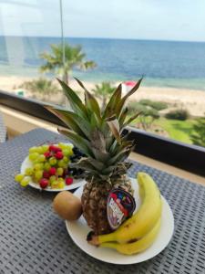 a plate of food with a pineapple and fruit on a table at Beachfront Dream, WaveHaus in Akouda