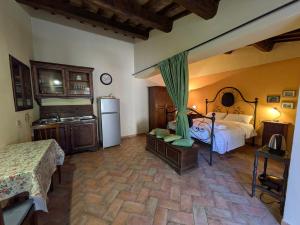a large room with a bed and a refrigerator at Agriturismo Il Giovannello in Roccastrada
