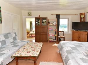 a living room with a couch and a tv at Sodyba Po liepom in Krikštonys
