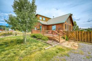 a log cabin with a deck and a fence at The Norma Charles in South Fork