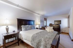 a bedroom with a large bed and a television at Lion Square Lodge North 296 in Vail +66 photos