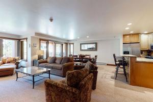 a living room with couches a table and a kitchen at Lion Square Lodge North 296 in Vail