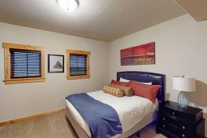 a bedroom with a bed and two windows at Urban Mountain Getaway & Alpenglow Chalet in Steamboat Springs