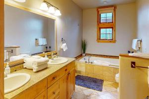 a bathroom with two sinks and a large mirror at Urban Mountain Getaway & Alpenglow Chalet in Steamboat Springs +23 photos