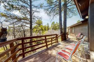 a porch with chairs and a fence and trees at Self-Reflection in Pagosa Springs
