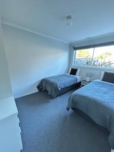 a bedroom with two beds and a window at Old Pier Apartments in Bridport