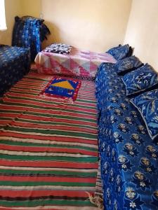 a bedroom with a bed and a rug at Gîte Chez habitant in Telouet
