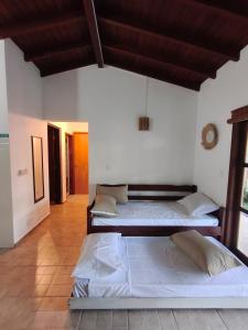 two beds in a room with white walls at Quinta do Sahy in São Sebastião +30 photos