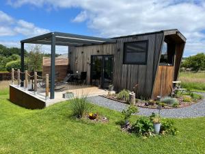 eine kleine Holzhütte mit Terrasse im Garten in der Unterkunft Tiny BlackandWood in Redu