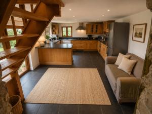 a large kitchen with a couch and a refrigerator at Ysgol Hill Main House in Rosebush