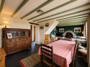 a dining room with a table and a living room at Ysgol Hill Main House in Rosebush
