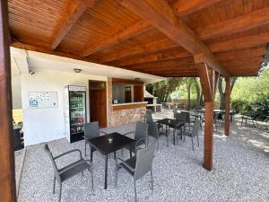 a patio with tables and chairs under a wooden roof at Studio Kolo-M in Blagaj