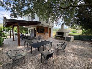 a patio with tables and chairs and a grill at Studio Kolo-M in Blagaj