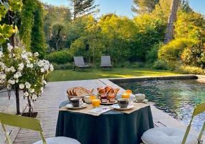 a table with food on it next to a pool at Villa Les Lucioles - Chambre indépendante - Piscine privative - Petit déjeuner - Parking in Valbonne