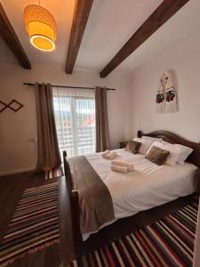 a bedroom with a large bed and a window at Carpathian Soul Maramures in Bogdan Vodă