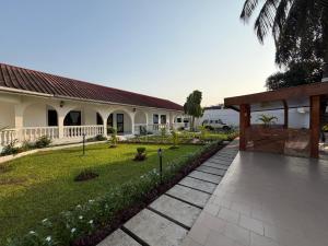 a house with a walkway in front of a yard at La Villa Eden in Pointe-Noire