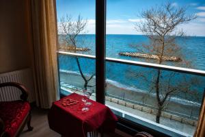a window with a table and a view of the ocean at Dolphins Otel in Akçakoca