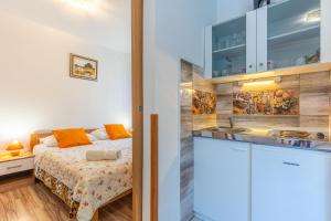 a small bedroom with a bed and a sink at Apartmani Vitković II Cres in Cres