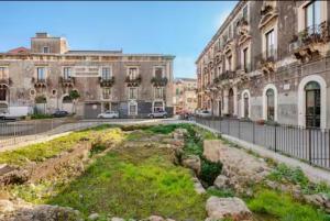a garden in the middle of a street with buildings at Dogana House in Catania