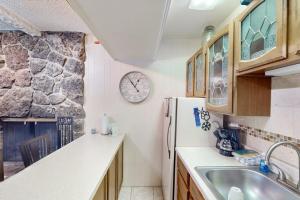 a kitchen with a refrigerator and a clock on the wall at Hi Country Haus Hideaway in Winter Park +47 photos
