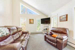 a living room with a brown leather couch and windows at Misty Meadow in Fraser