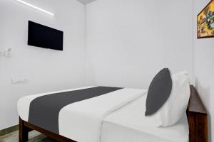a bedroom with a bed with a tv on the wall at Hotel O EVA RESIDENCY in Cochin