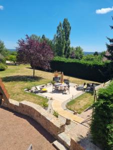a garden with a table and chairs and a patio at Rouvray 21 in Rouvray