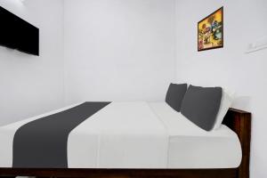 a bedroom with a white bed and a tv at Hotel O EVA RESIDENCY in Cochin
